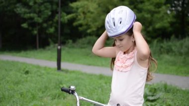Küçük sevimli kız bisiklet kaskı takıyor.