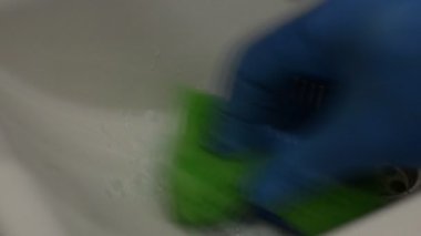 Temizlikçi lavaboyu ev kimyasallarıyla temizliyor.