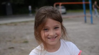 Küçük sevimli kız çocuk parkta salıncakta sallanıyor