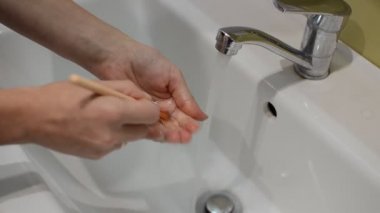 Kadınlar makyaj fırçalarını musluk suyuyla yıkıyor.