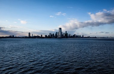 New York şehir manzarası ile Hudson Nehri üzerinde kentsel gökdelenler. Manhattan şehir panoraması. Gün batımında limana su manzaralı