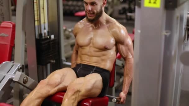 Athletic Man Performs Extension Leg Exercise Simulator — Stock Video