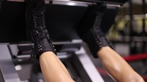 运动女孩在模拟器中执行腿部压榨练习 — 图库视频影像