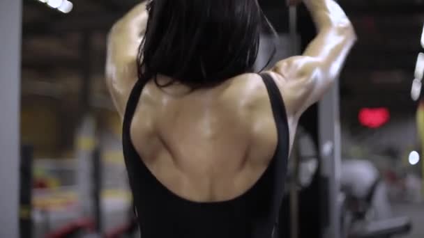 Athletic girl performs a breeding exercise for the back delta — Stock Footage Athletic Girl Performs Breeding Exercise Back Delta Video Clip