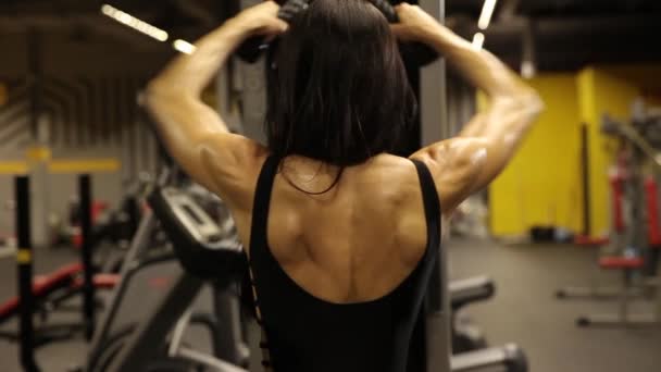 Athletic girl performs a breeding exercise for the back delta — Stock Footage Athletic Girl Performs Breeding Exercise Back Delta Stock Footage