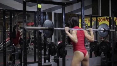 Atletik kız bir halter ile çömelmiş