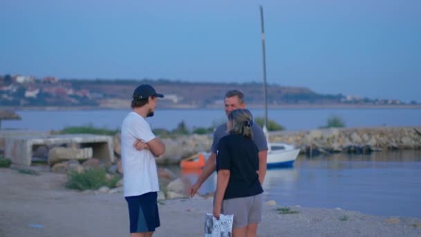 Tři lidé mluví na černomořské pláži fregata Odessa Září 12, 2020 — Stock video