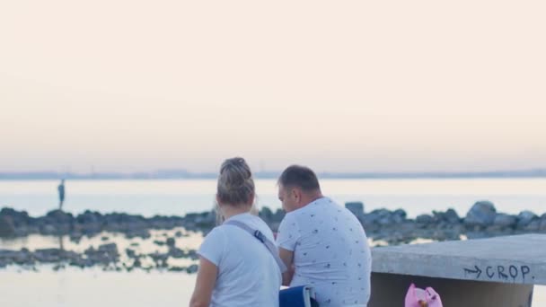 Egy férfi és egy nő ül a fekete tenger partján a fregatt strandon 2020. szeptember 12-én Odessza városában. — Stock videók