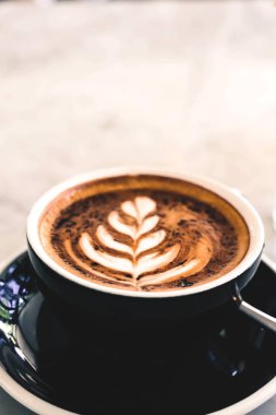 Mermer masa arka planda siyah Kupası fincan sıcak cappucino açıktır. Çiçek kapalı