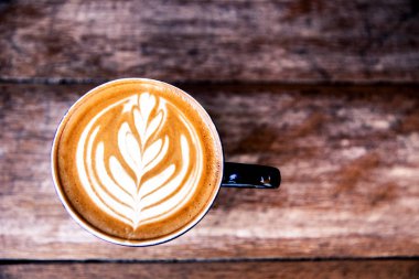 Ahşap masa arka plan üzerinde bu, sıcak cappucino. hippster tarzı