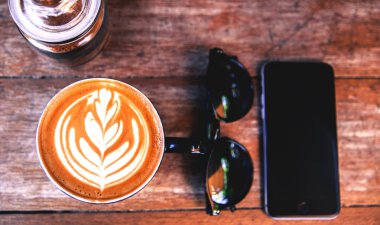 Ahşap masa arka plan üzerinde bu, sıcak cappucino. hippster tarzı