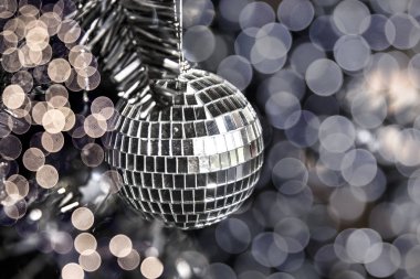 Bulanık ışıkları ile Noel ağacı üzerinde gümüş parlak disko oyuncak topu. Tatil kavramı. Yakın çekim.