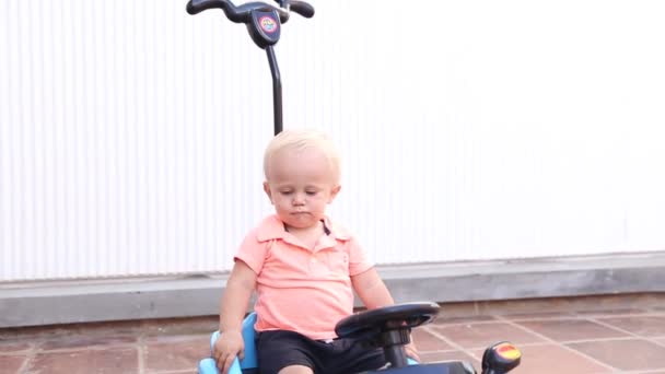 Pequeno Menino Loiro Bonito Está Examinando Montando Brinquedo Carro Azul — Vídeo de Stock