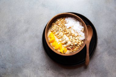 Mango smoothie kase çilek ve Hindistan cevizi ve masanın üzerine yulaf ezmesi ile.