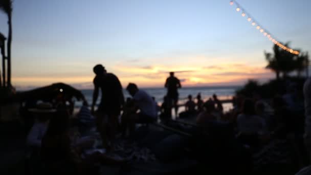 Fiesta en la playa al atardecer con amigos cerrados a la piscina con vista al mar . — Vídeo de stock