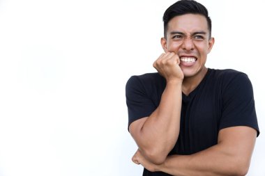 Genç adam beyaz arka planda dururken yanağını tutuyor..