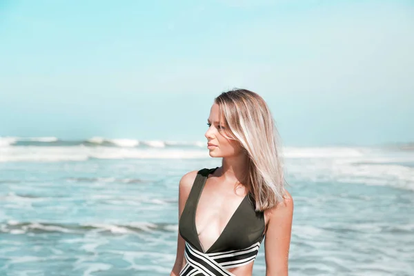 Retrato de una joven hermosa mujer en bikini verde en la playa tropical . — Foto de Stock