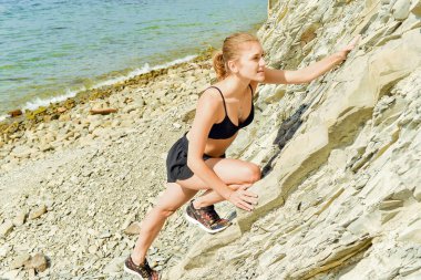  Genç kadın egzersiz yapıyor ve gerinmeler yoga yapıyor.