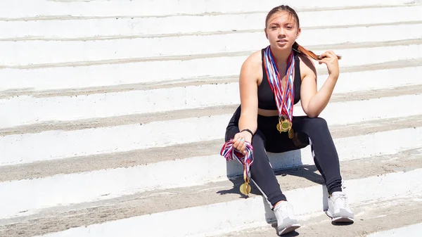 Ένα κορίτσι με αθλητική στολή κάθεται στα σκαλιά. — Φωτογραφία Αρχείου