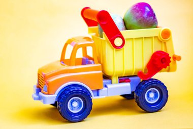 Sarı arka planda, elmalı oyuncak kamyonet. Meyve nakliyatı.