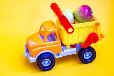 Sarı arka planda, elmalı oyuncak kamyonet. Meyve nakliyatı.