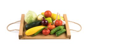 Taze meyve: domates, salatalık, kabak, biber ve lahana tahta tepside beyaz bir zemin üzerinde.