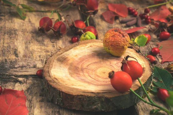 Осенний состав ягод и сушеных фруктовых листьев на естественном деревянном фоне. — стоковое фото