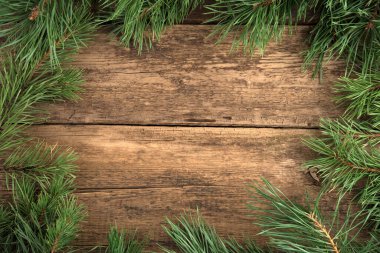 Doğal ahşap arka planda taze çam dallarından yapılmış Noel süsü..