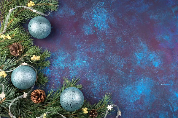 З Новим 2021 роком Різдвяна рамка з соснових гілок з жовтими сухими квітами та синіми іграшками на синьому бетонному фоні . — стокове фото
