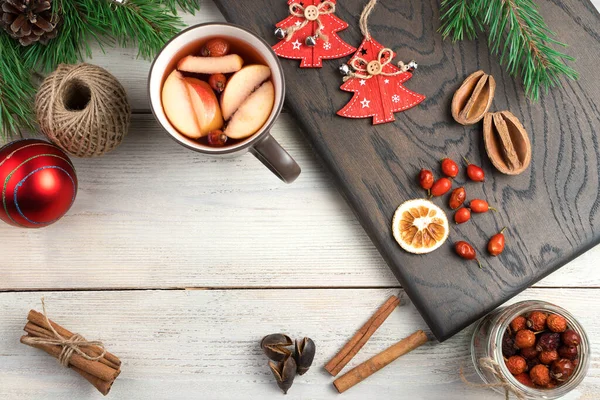A Cup of mulled wine, berries and dried citrus, cinnamon sticks, fir branches and toys on the Board top view. — Stock Photo, Image