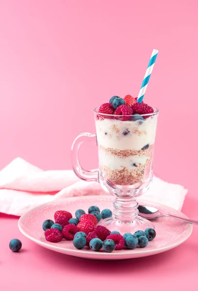 Beautiful dessert with cream and strawberries, raspberries, blueberries on a soft pink background. — Stock Photo, Image