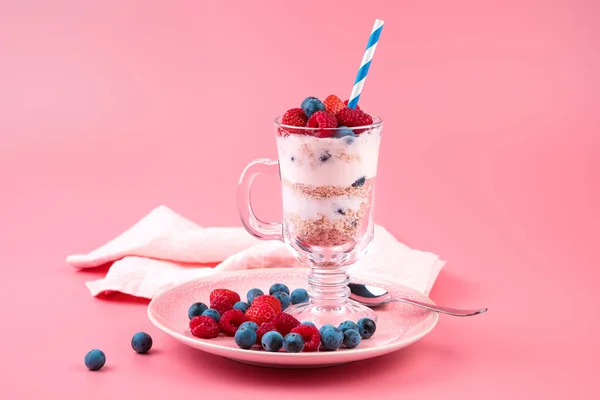 Berries and curd dessert with a glass on a pink background. Side view. — Stock Photo, Image