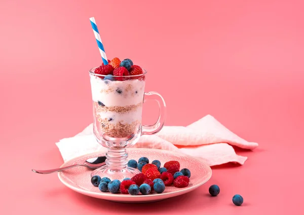 Dessert with berries, nuts and cream on a soft pink background. — Stock Photo, Image