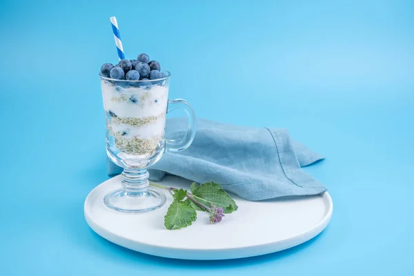 Creamy dessert with blueberries on a soft blue background. — Stock Photo, Image