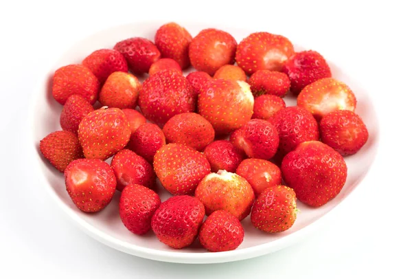 Strawberries on a white plate on a light background. Berry background. — Stock Photo, Image