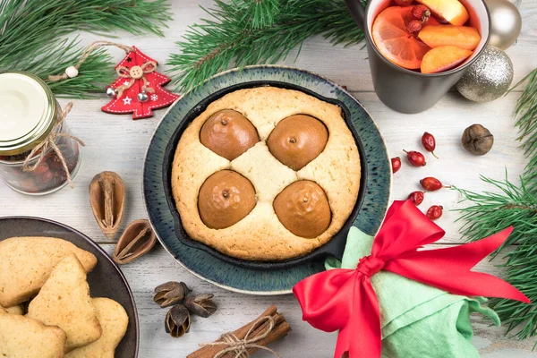 Home-made pie with pears decorated with a red bow, a Cup with a Christmas drink and cookies on a white background. — Stock Photo, Image