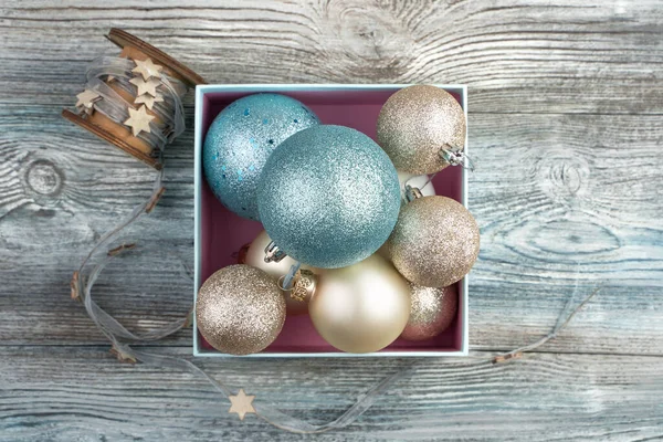 Багато різних різдвяних кульок і стрічка з зірками на дерев'яному сірому фоні . — стокове фото