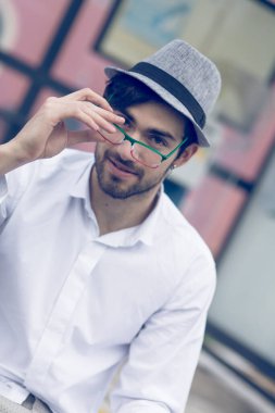 Gri şapkalı ve göz portresi çizen güzel koyu renk saçlı gri şapkalı ve gözlüklü güzel bir çocuk portresi. Yüksek kalite fotoğraf