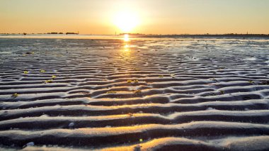 Akdeniz sahillerinde gün doğumunda riccione rimini 'de güneş kum ve dalgaları yansıtıyordu.