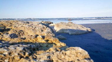 Akdeniz kıyısındaki kayalar Rimini Riccione plajı ve kumlu gün batımında