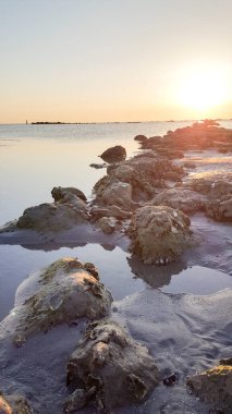 Akdeniz kıyısındaki kayalar Rimini Riccione plajı ve kumlu gün batımında