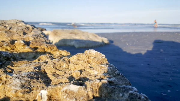 地中海の海岸にある岩リミニ リシオーネビーチと砂で日没 — ストック写真