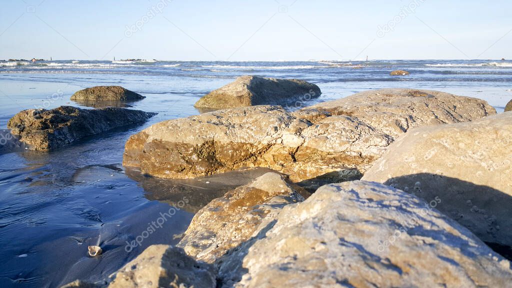 rocks on the shore of the Mediterranean sea Rimini Riccione with beach and sand at sunset