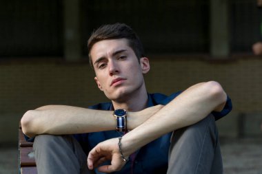 Güzel siyah saçlı çocuk Milan parkında bir bankta otururken poz veriyor. Yüksek kalite fotoğraf