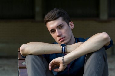 Güzel siyah saçlı çocuk Milan parkında bir bankta otururken poz veriyor. Yüksek kalite fotoğraf