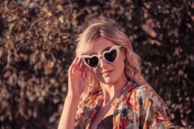 Buğday tarlasında iç çamaşırı ve güneş gözlükleriyle poz veren güzel sarışın kız. Yüksek kalite fotoğraf