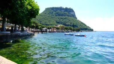 Garda göl rıhtımında tepe ve dalgalarla güneşli bir günde Yüksek kaliteli FullHD görüntüleri