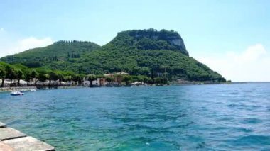 Garda göl rıhtımında tepe ve dalgalarla güneşli bir günde Yüksek kaliteli FullHD görüntüleri