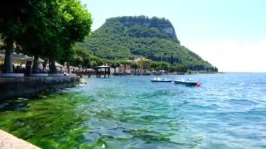 Garda göl rıhtımında tepe ve dalgalarla güneşli bir günde Yüksek kaliteli FullHD görüntüleri