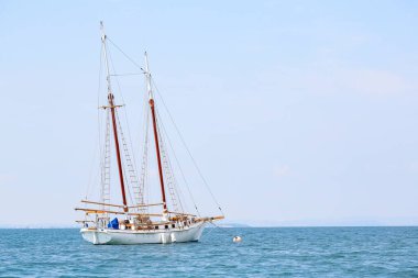 Garda Gölü 'nde, Sirmione açıklarında gün batımında dalgaların olduğu kadim bir tekne. Garda Gölü 'nde Sirmione açıklarında yüksek kaliteli bir tekne Sunsethoto' da dalgaların altında sallanıyor.